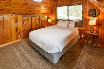 a bedroom with a bed in a wooden cabin at Harris Lakeview Cabin in Bass Lake