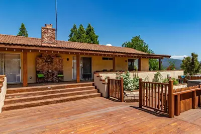a house with a wooden deck with stairs at Putney Place in North Fork