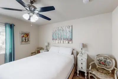 a bedroom with a white bed and a ceiling fan at Putney Place in North Fork