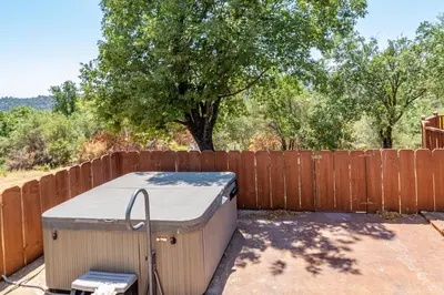 a hot tub in a backyard next to a fence at Putney Place in North Fork