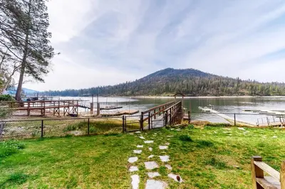 a path next to a lake with a mountain at Humphreys Lakefront in Bass Lake