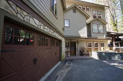 a house with a brown garage door and a driveway at Humphreys Lakefront in Bass Lake