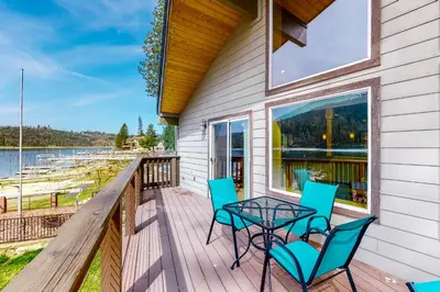 a deck with a table and chairs and a view of the water at Humphreys Lakefront in Bass Lake