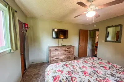 a bedroom with a bed and a ceiling fan at Hodges Hill Yosemite House in Oakhurst