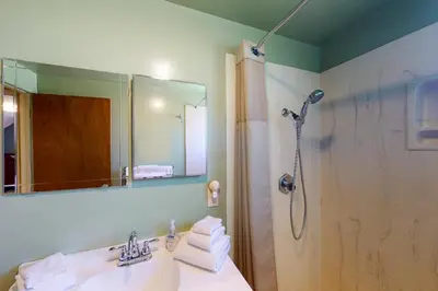 a bathroom with a shower and a sink and a mirror at Hodges Hill Yosemite House in Oakhurst