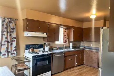 a small kitchen with a stove and a sink at Hodges Hill Yosemite House in Oakhurst