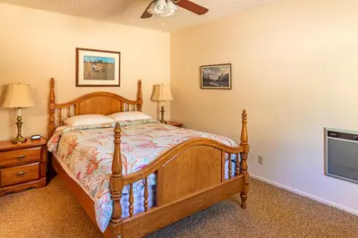 a bedroom with a bed and a flat screen tv at Miglin Lakeview in Bass Lake