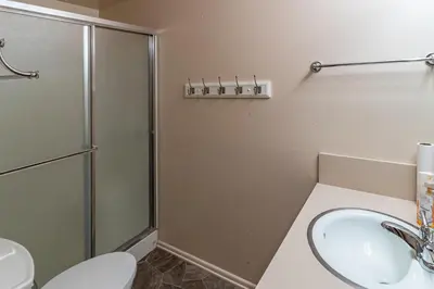 a bathroom with a shower and a sink and a toilet at Miglin Lakeview in Bass Lake