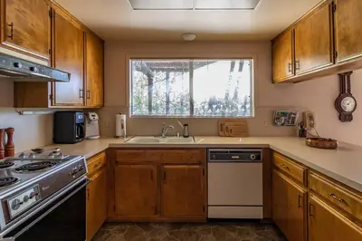 a kitchen with wooden cabinets and a sink and a window at Miglin Lakeview in Bass Lake