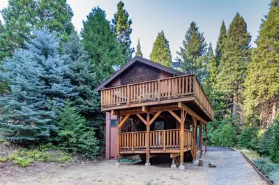 a large wooden cabin in the middle of a forest at Yosemite Big Rock Cabin in Fish Camp