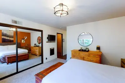 a bedroom with a large bed and a mirror at Yosemite Big Rock Cabin in Fish Camp