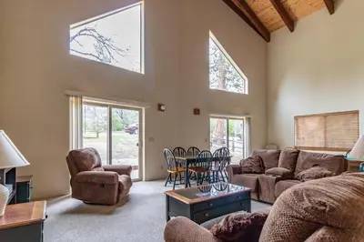 a living room with a couch and a table and chairs at Streiff Lake House in Bass Lake