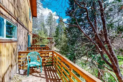 a wooden deck with a blue chair on it at Streiff Lake House in Bass Lake