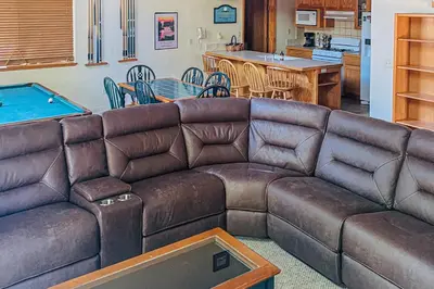 a living room with a brown couch and a pool table at Streiff Lake House in Bass Lake