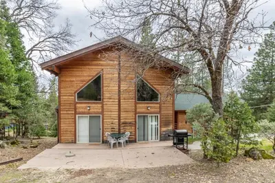 a log cabin with a table and a chair at Streiff Lake House in Bass Lake