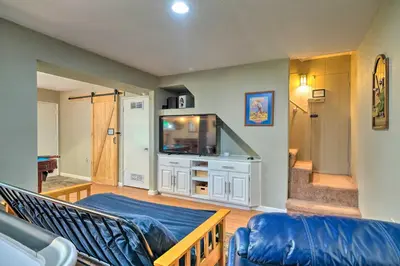 a living room with a couch and a television at Game Room and Deck Oso Cozy Cabin in Arnold! in Arnold