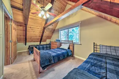 a bedroom with two beds and a ceiling fan at Game Room and Deck Oso Cozy Cabin in Arnold! in Arnold