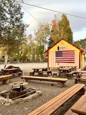 a building with an american flag on it with picnic tables at Willow Springs Resort in Bridgeport