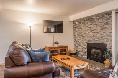 a living room with a couch and a fireplace at Warm and cozy upgraded 2 bedrm 2 bath single level condo in Snowcreek complex phase IV 563 Sleeps 6 in Mammoth Lakes