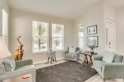a living room with a couch and chairs and windows at 8 Mi to Dtwn Reno Cozy Sparks Escape with Fireplace in Sparks