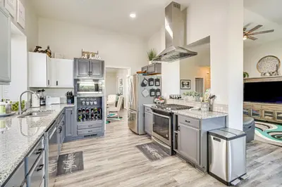 a large kitchen with stainless steel appliances and wooden floors at 8 Mi to Dtwn Reno Cozy Sparks Escape with Fireplace in Sparks