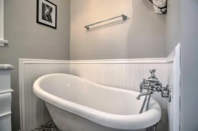 a white bath tub in a white bathroom at Vintage Bishop House in Downtown with Porch Swing! in Bishop