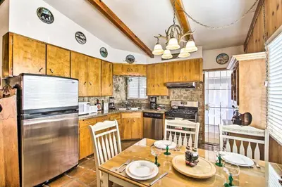 a kitchen with wooden cabinets and a table and chairs at Kernville - walk to River Kern & Downtown in Kernville
