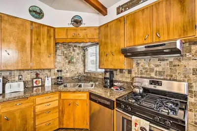 a kitchen with wooden cabinets and a stove top oven at Kernville - walk to River Kern & Downtown in Kernville