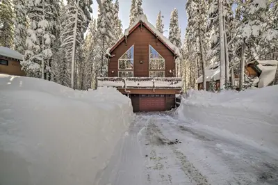 a snow covered road leading to a log cabin at Great for Groups Soda Springs Cabin with Deck! in Soda Springs