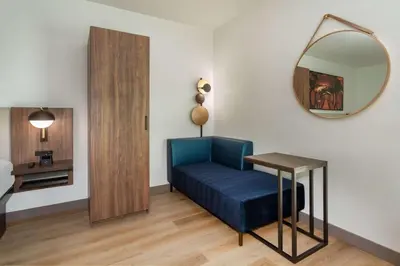 a room with a blue chair and a table and a mirror at La Quinta Inn & Suites by Wyndham Galt Lodi North in Galt
