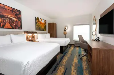 a hotel room with two beds and a desk at La Quinta Inn & Suites by Wyndham Galt Lodi North in Galt