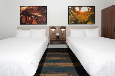 two beds in a room with white sheets at La Quinta Inn & Suites by Wyndham Galt Lodi North in Galt