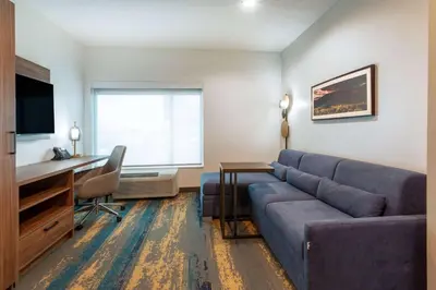 a living room with a couch and a desk at La Quinta Inn & Suites by Wyndham Galt Lodi North in Galt