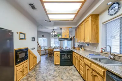 a kitchen with wooden cabinets and a counter top at Black Bear Cabin in Bass Lake