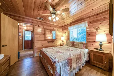 a bedroom with a bed and a ceiling fan at Black Bear Cabin in Bass Lake