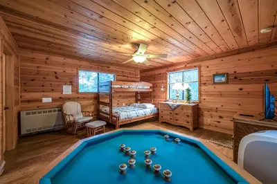 a log cabin bedroom with a pool table at Black Bear Cabin in Bass Lake