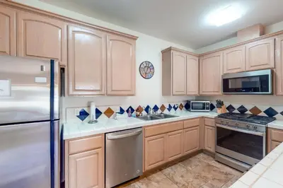 a kitchen with wooden cabinets and stainless steel appliances at Willard Lake House in Bass Lake