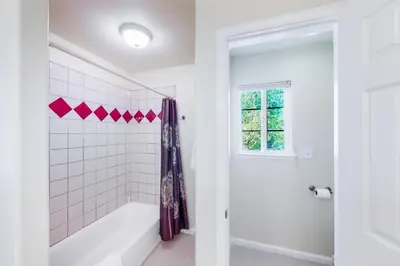a white bathroom with a tub and a shower at Willard Lake House in Bass Lake