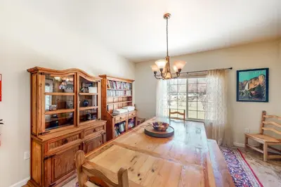 a dining room with a wooden table and a chandelier at Willard Lake House in Bass Lake