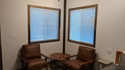 a room with two chairs and a table and two windows at Clingan's Junction Cottage #4 in Squaw Valley