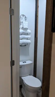 a bathroom with a toilet and a pile of towels at Clingan's Junction Cottage #4 in Squaw Valley