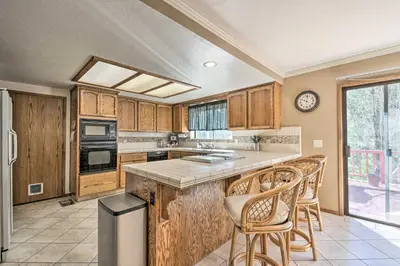 a kitchen with wooden cabinets and a counter top at Deck and Hot Tub Rustic Groveland Home! in Groveland