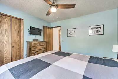 a bedroom with a bed and a ceiling fan at Deck and Hot Tub Rustic Groveland Home! in Groveland