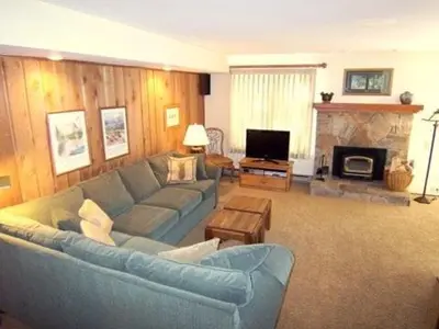 a living room with a blue couch and a fireplace at 1 Bedroom Standard Condos in Mammoth Lakes