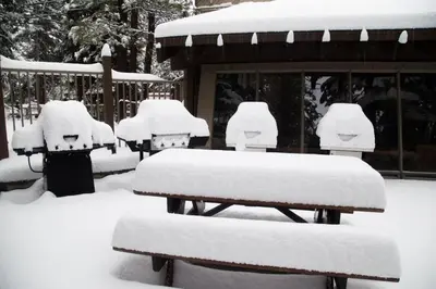 a group of benches covered in snow in front of a house at 1 Bedroom Premium Condos in Mammoth Lakes