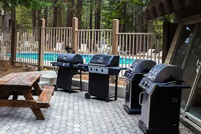 a group of grill and picnic tables and a bench at 1 Bedroom Premium Condos in Mammoth Lakes