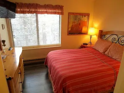 a bedroom with a bed with a red blanket and a window at 2 Bedrooms Premium Condos in Mammoth Lakes