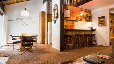 a room with a bar with stools and a table at 2 Bedrooms Standard Condos in Mammoth Lakes