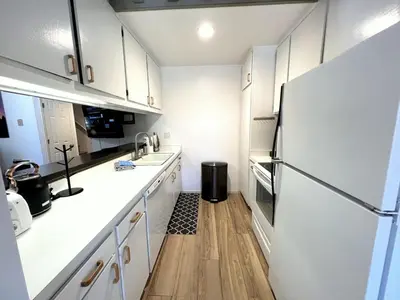 a kitchen with white cabinets and a refrigerator at 2 Bedrooms Standard Condos in Mammoth Lakes