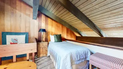 a bedroom with a bed and a wooden wall at Discover 4 in Mammoth Lakes